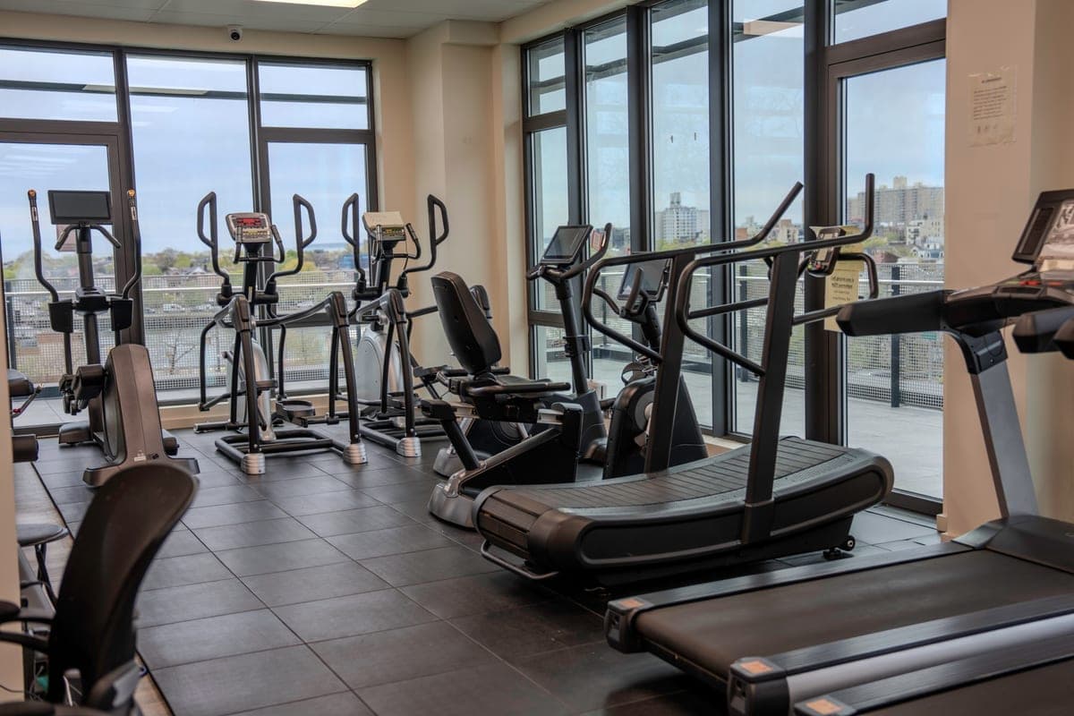 Cardio machines overlooking the neighborhood through floor-to-ceiling windows